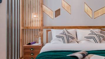 A bedroom with a bed, a nightstand, a wall-mounted light fixture, and a decorative wall panel.
