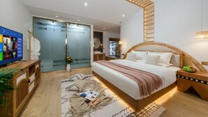 A modern bedroom with a large bed, bedside tables, a TV, and a glass door leading to a bathroom. - Yunyin Sanqiu Inn (Deqin)