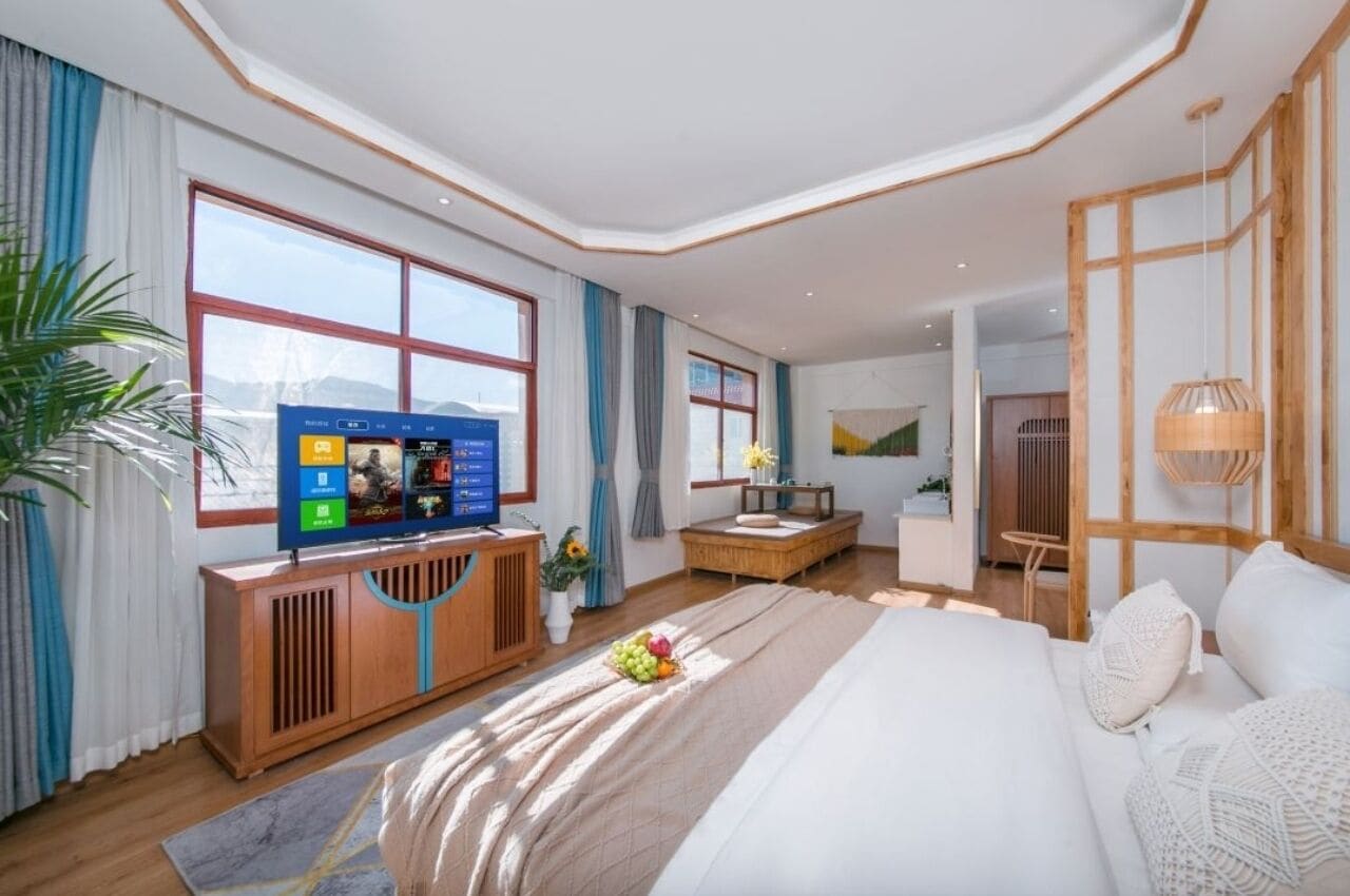 Een moderne hotelkamer met een groot bed, een televisie, een bureau en een raam met gordijnen.