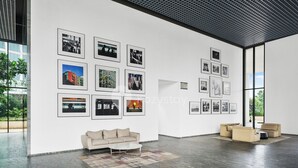Une galerie spacieuse au décor moderne, comprenant un canapé et une table basse, et dont les murs sont ornés de photographies encadrées.