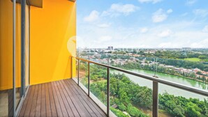 Un balcon avec vue sur une rivière et sur le paysage urbain.
