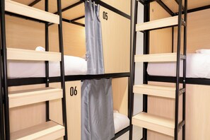 Une chambre avec des lits superposés, des structures en bois et des lits numérotés.