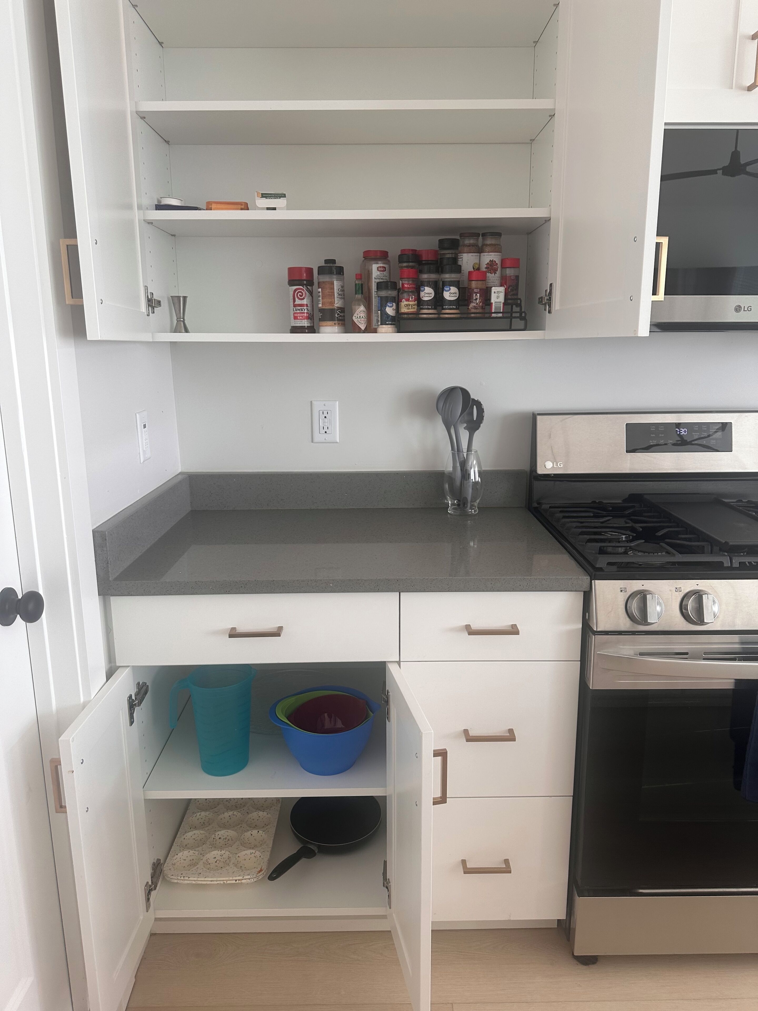 A kitchen with white cabinets, a stainless steel stove, and a microwave above the counter.
