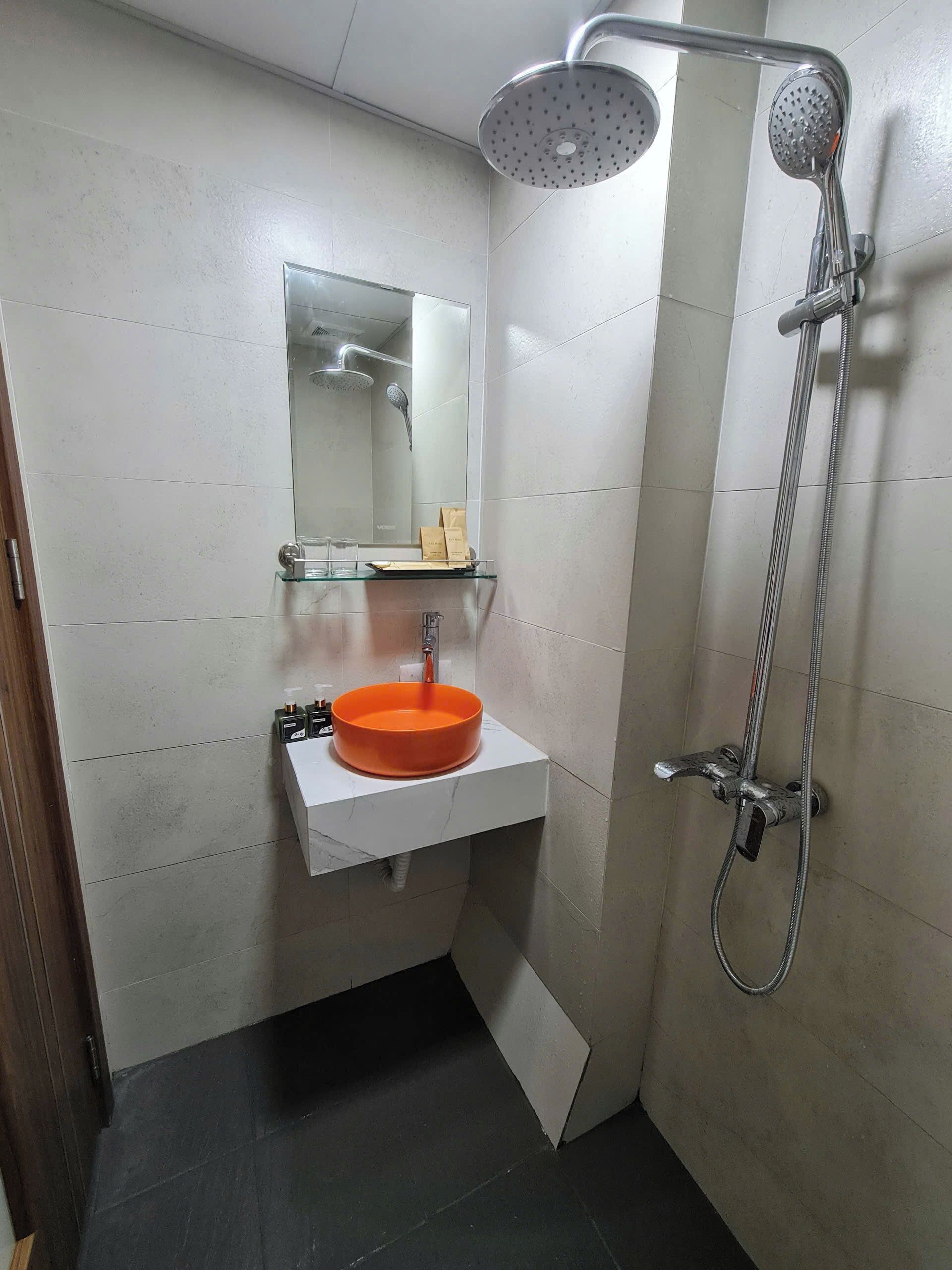 A bathroom with a white sink, a mirror, and a shower.