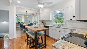 Una cocina moderna con armarios blancos, encimera de granito y lavavajillas integrado.