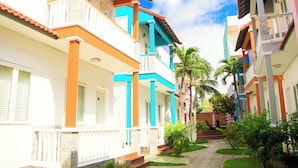 A residential building with balconies, a pathway, and greenery. - Volga Hotel & Appartment Mui Ne (Mui Ne)