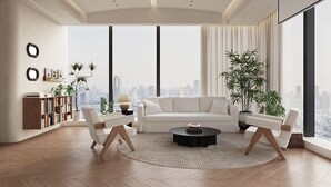 A modern living room with a white sofa, two armchairs, a coffee table, and a large window offering a city view. - Ziggy Hotel (Changsha)