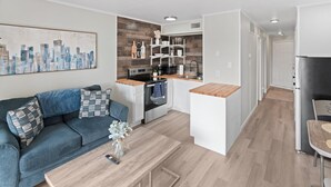 A modern apartment with a kitchenette, a dining area, and a living room. - Just Beachy (Corpus Christi)