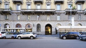 Un edificio de varios pisos con estilo arquitectónico clásico, que presenta una entrada central con un arco y una serie de ventanas en cada planta.