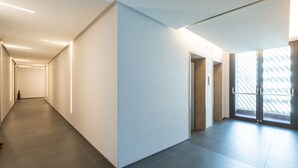 A modern, well-lit hallway with a glass door leading to an outdoor area. - Charmant onebedroom Isola A (Milano)