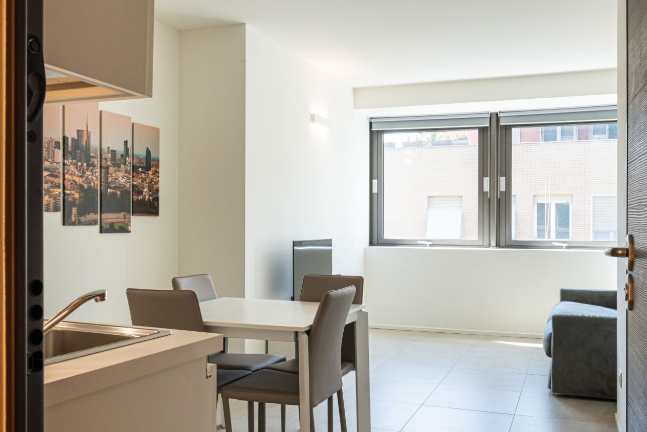 Una cucina moderna con zona pranzo, un'ampia finestra vista città e un piccolo angolo relax.