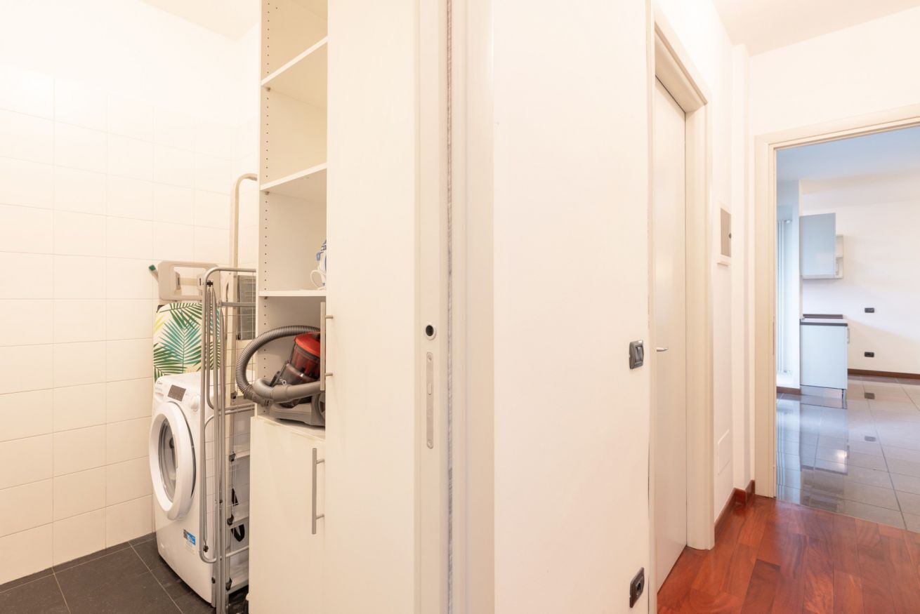 A laundry area with a washing machine, a dryer, and a utility cart.