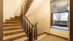 Una escalera con escalones de mármol y barandilla de metal.