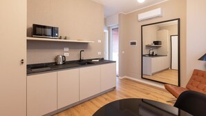 Una cocina moderna con microondas, hervidor y pileta.