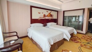 A hotel room with two beds, a small table, and a chair. - VN hotel -Guangdong Heyuan Hongxing road (Heyuan)