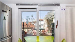 Quarto com porta de correr de vidro que dá para área externa com mesa e cadeiras.