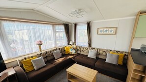 A cozy living area with a sofa set, a coffee table, and a TV on a stand. - StaticHome-Sleeps6-Lakeview-Balcony-Parking-PetsOK (Mablethorpe)