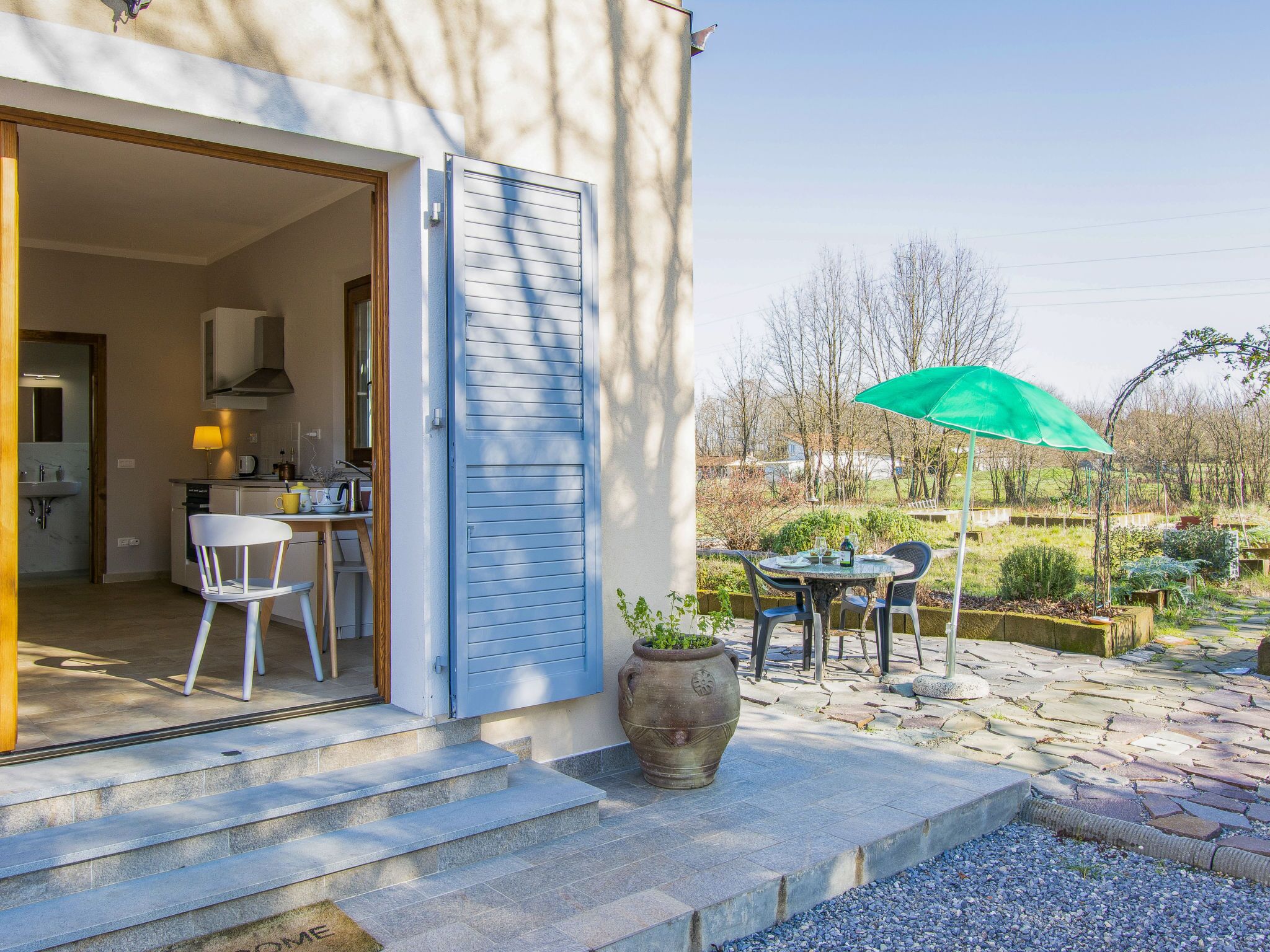 Ein modernes Haus mit Küche, Essbereich und einer Außenpatio mit Tisch und Stühlen.