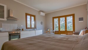 A bedroom with a large bed, a small table, and a window with a view of trees. - Lavanda by Interhome (Fucecchio)