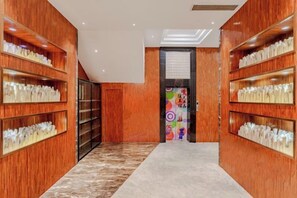 Un pasillo con estanterías de madera a ambos lados, que conduce a una puerta con un diseño colorido.
