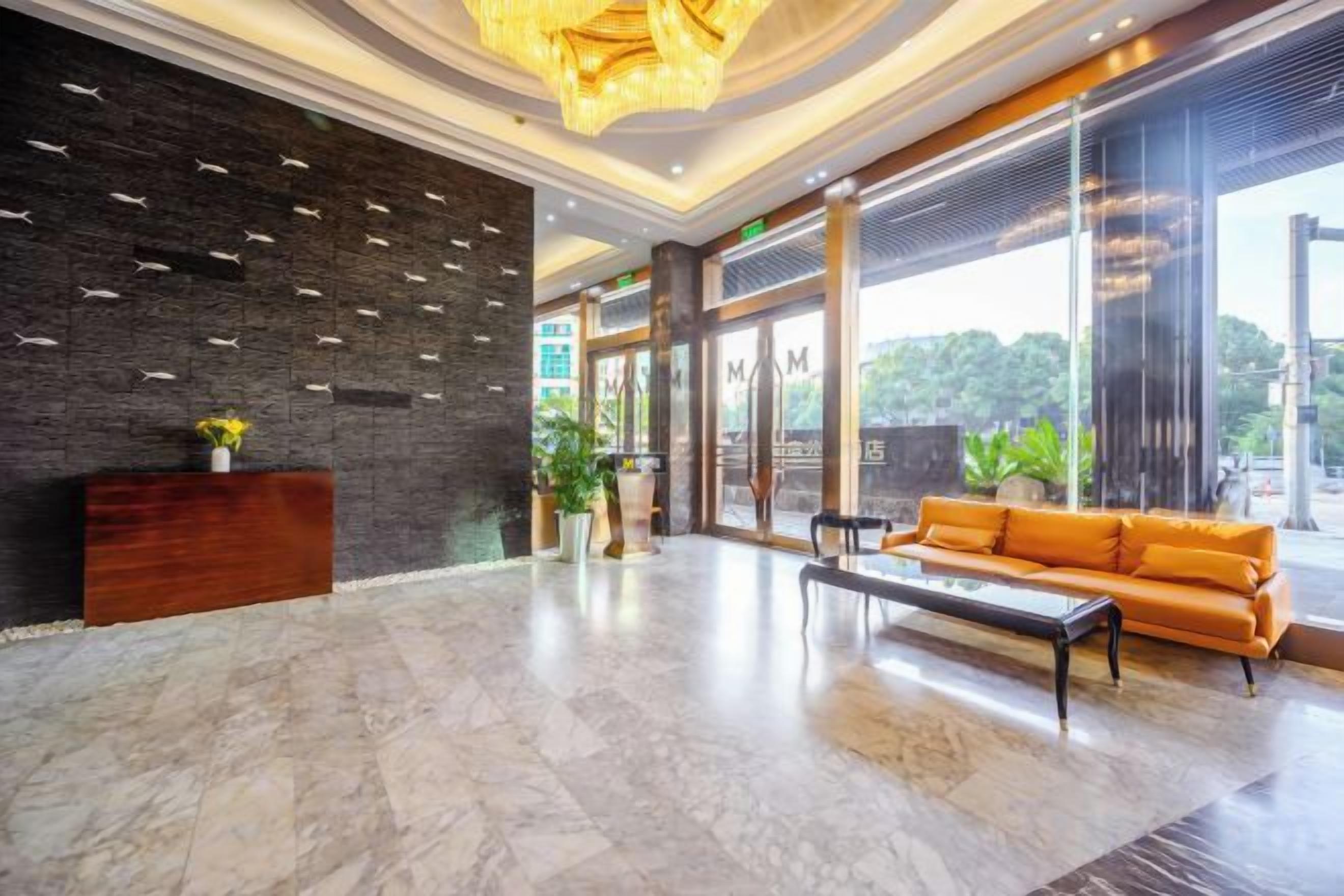 A lobby with a reception desk, seating area, and large windows.