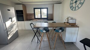 Una cucina moderna con isola centrale, forno integrato e un orologio da parete grande.