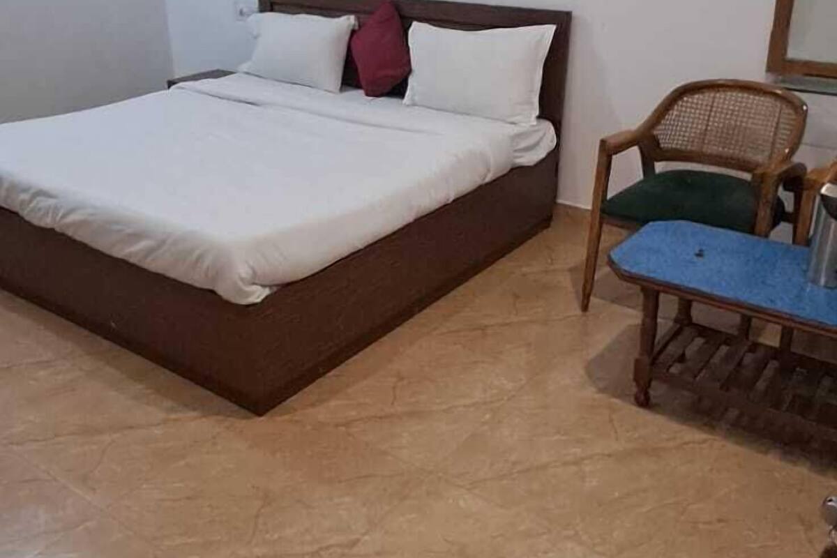 A bedroom with a bed, a chair, and a ceiling fan.