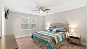 A bedroom with a bed, a nightstand, a ceiling fan, and a window. - The Cedar at Ducks Landing (Aberdeen)