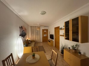 A dining area with a table, chairs, a lamp, a sofa, a television, and a cabinet with plants. - Ground Floor Casa Bonita with 2 Com Pools R5.37 (Orihuela)