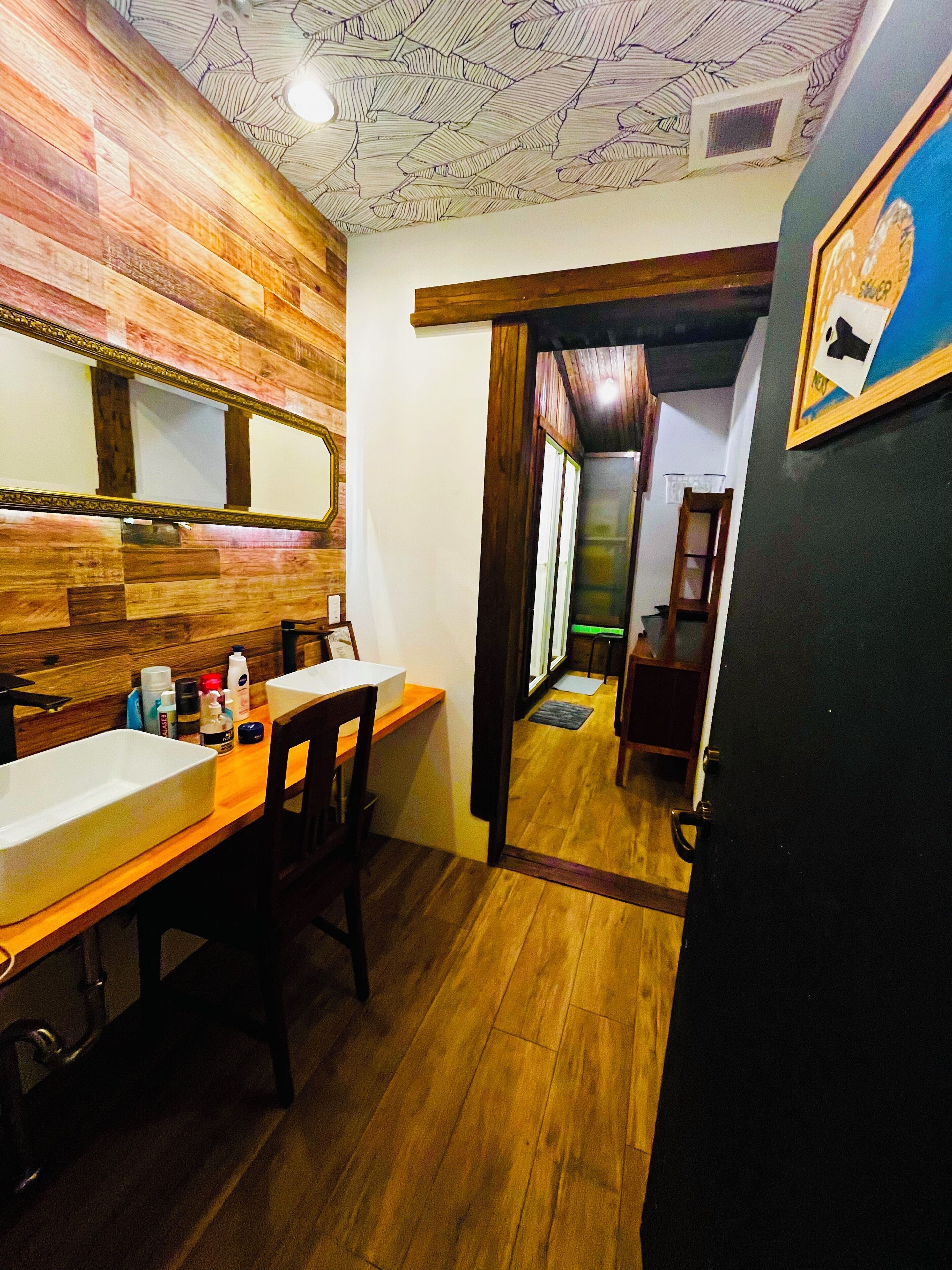 A bathroom with a wooden vanity, a mirror, and a sink.