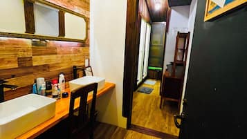 A bathroom with a wooden vanity, a mirror, and a sink.