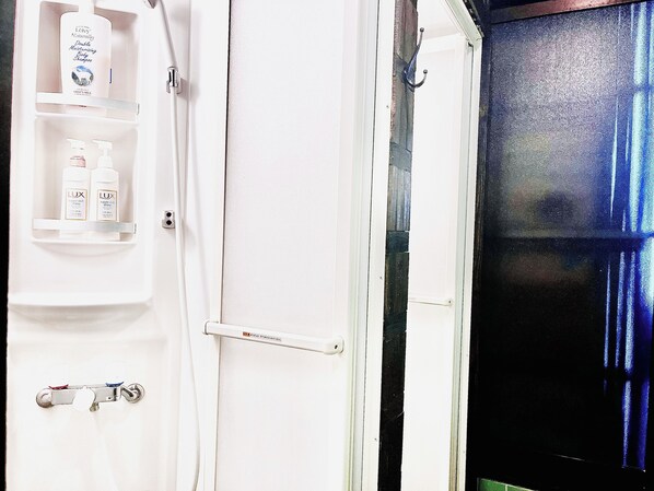 Un baño con un lavabo blanco, un espejo y un estante con artículos de aseo.