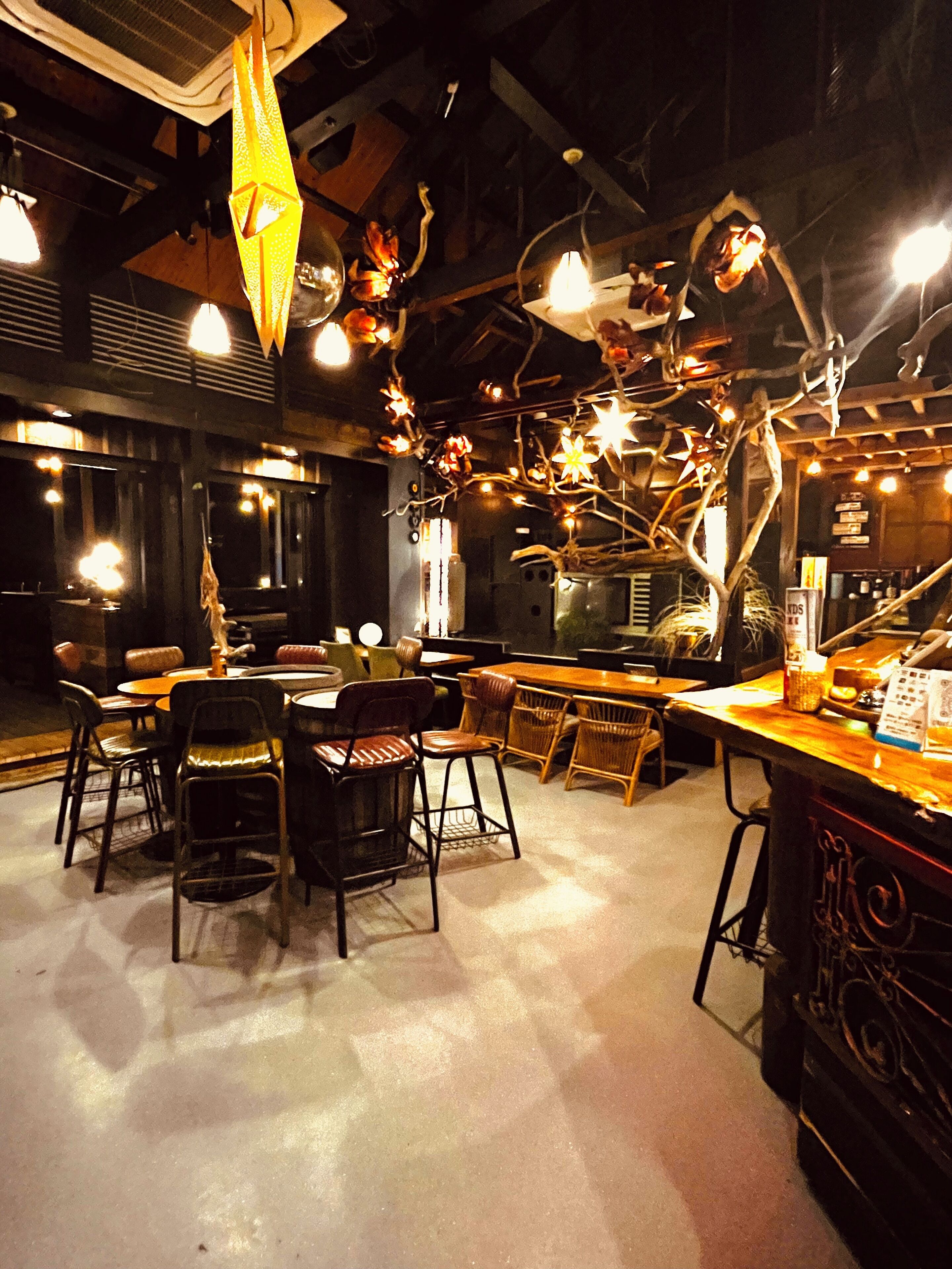 A restaurant interior with a bar area, dining tables, and chairs.
