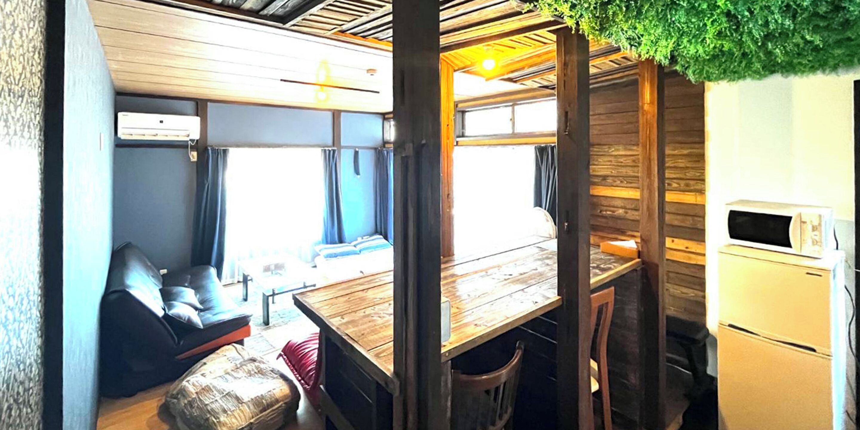 Una cocina funcional con una mesa de madera, un refrigerador y un microondas.