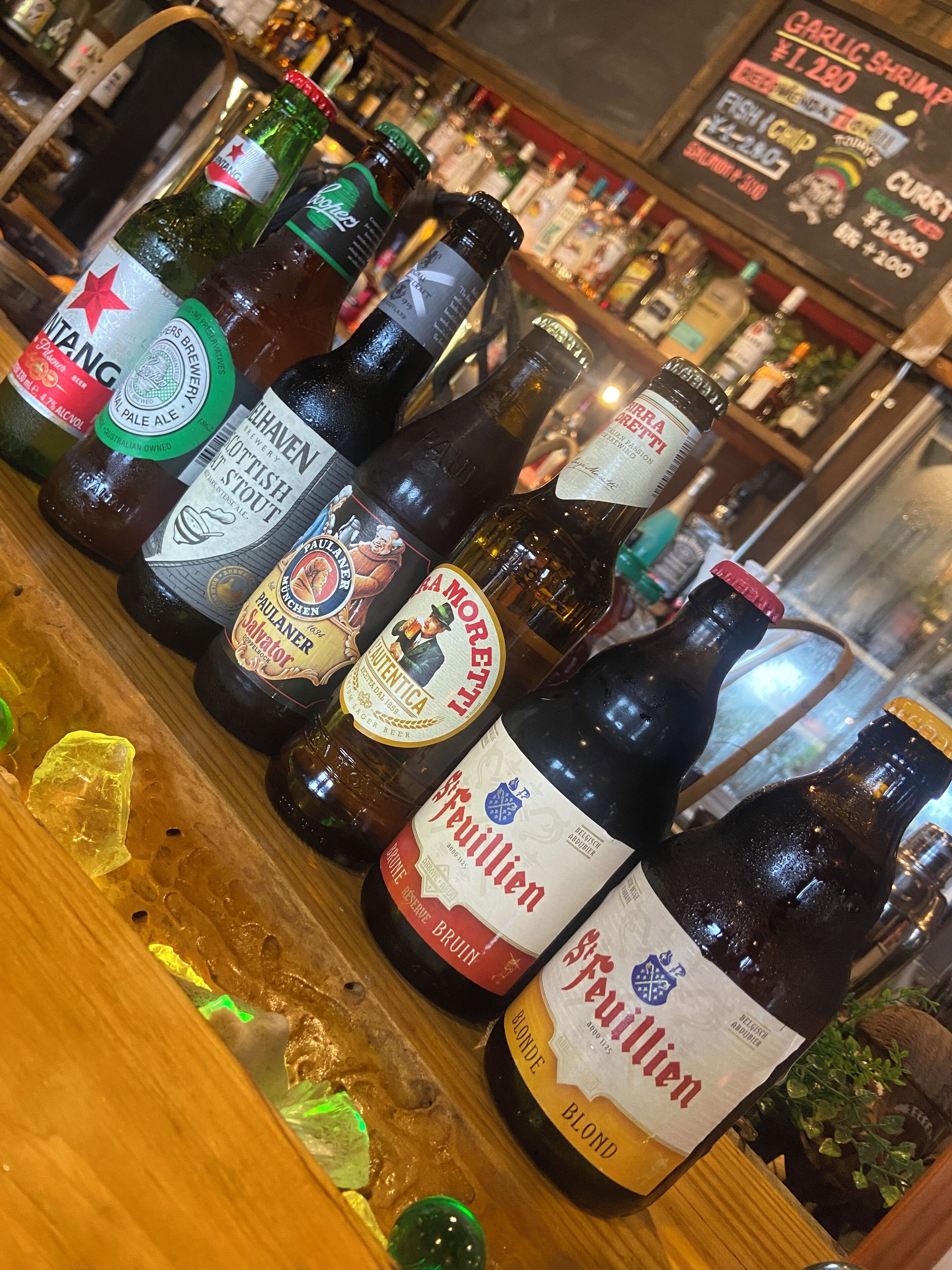 Un bar avec différentes bouteilles de bière et de spiritueux exposées sur des étagères.
