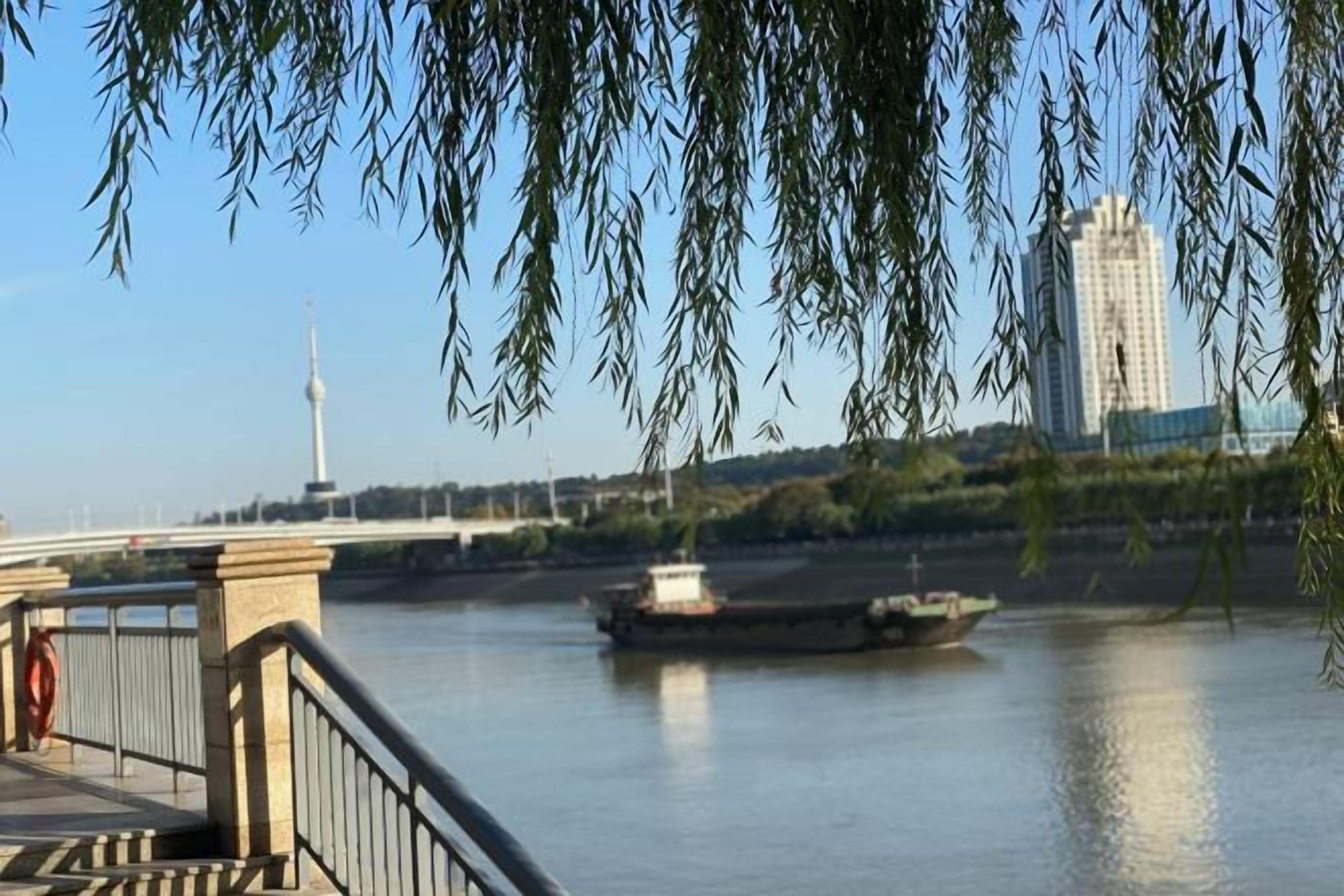 A river with a bridge and a boat.