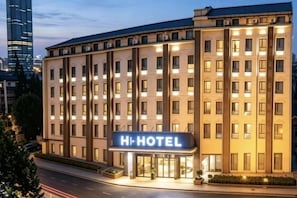 A multi-story hotel with a prominent 'HI HOTEL' sign, a clean facade, and a well-lit entrance. - H Hotel (Wuhan Hanzheng Street Chongren Road Metro Station Jiangtan Branch) (Wuhan)