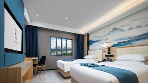 Una habitación de hotel con dos camas, un escritorio y un ventanal grande.