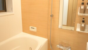 A modern bathroom with a bathtub, a toilet, and a shower. - KARAHORI NODOKA (Osaka)