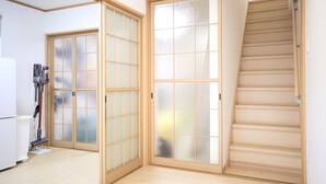 A room with sliding doors, a staircase, and a vacuum cleaner. - KARAHORI NODOKA (Osaka)