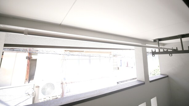 A room with a window overlooking a balcony, a ceiling fan, and a white wall. - KARAHORI NODOKA (Osaka)