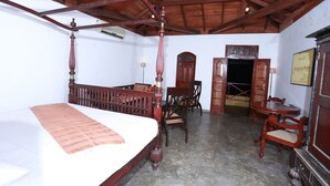Una habitación con una cama con dosel, muebles de madera y un techo alto.
