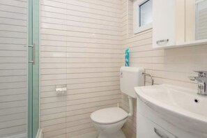 A bathroom with a toilet, sink, and shower area. - Apartment Alice close to Pula centre (Pula)