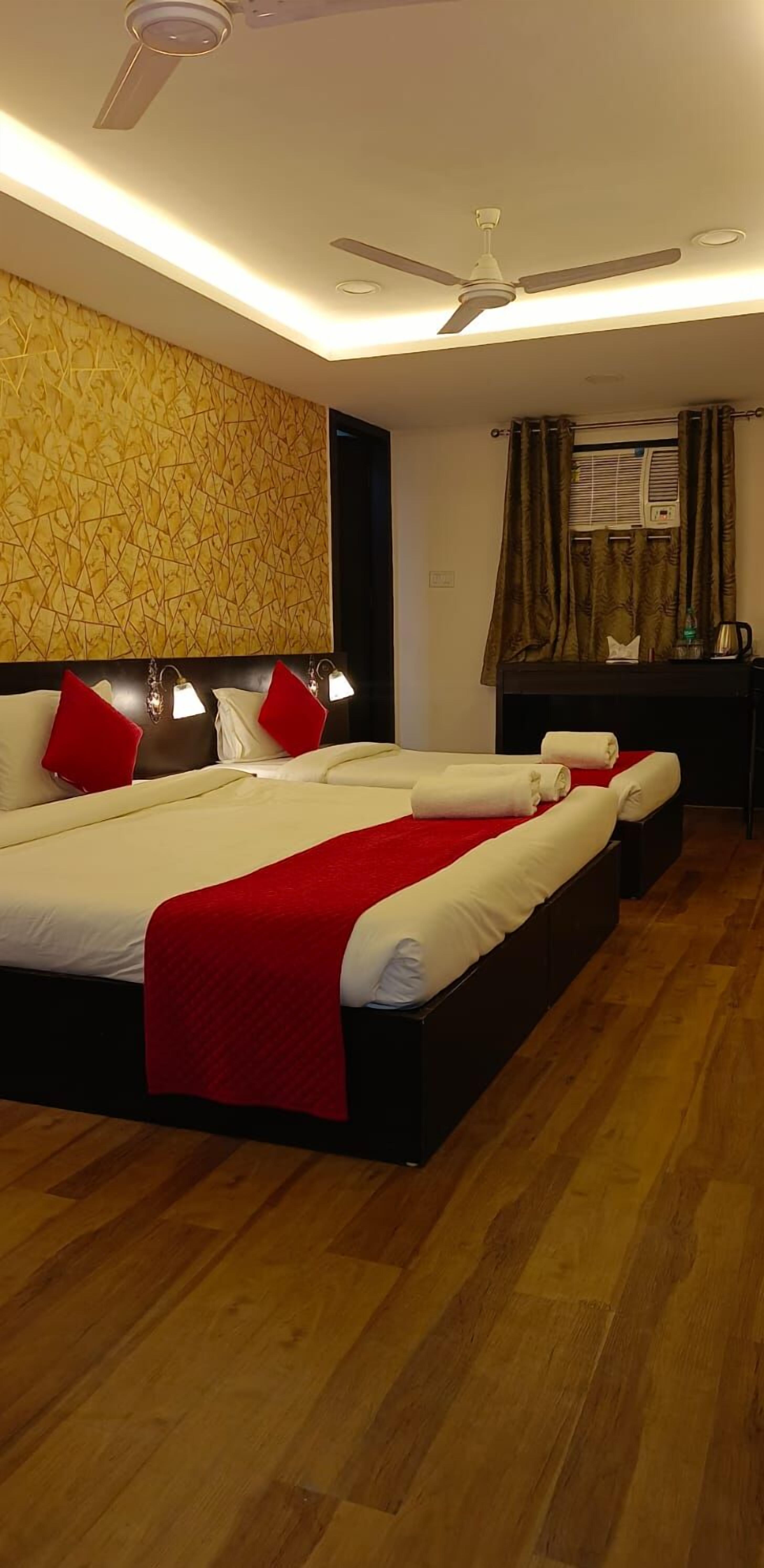 A hotel room with a large bed, a ceiling fan, and a patterned wall.