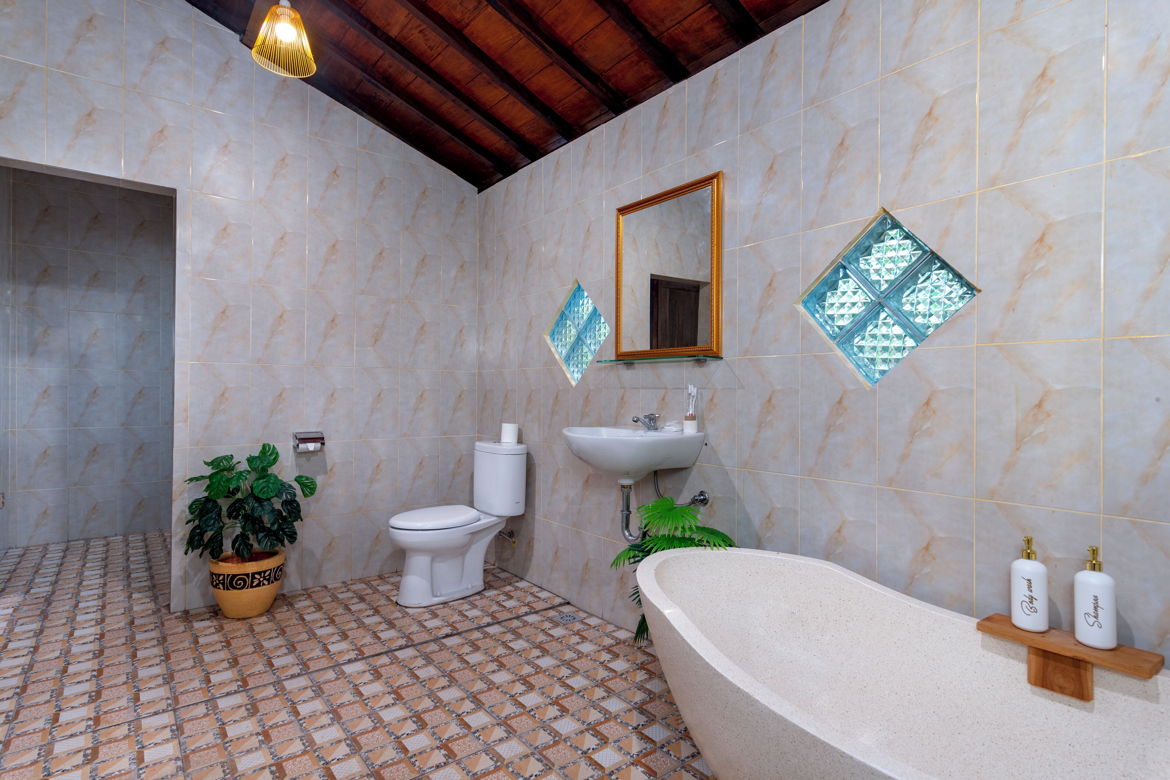 A bathroom with a bathtub, toilet, sink, and potted plants.