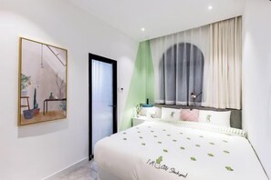 Un dormitorio moderno con cama, mesita de noche, ventana con cortinas, un cuadro colgado en la pared y una puerta.