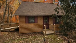 A wooden cabin with a front porch, a door, and windows. - Cabin, Hot Tub, Forest View, Close to Town (West Jefferson)