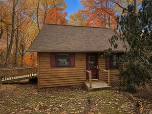 A wooden cabin with a front porch, a door, and windows. - Cabin, Hot Tub, Forest View, Close to Town (West Jefferson)