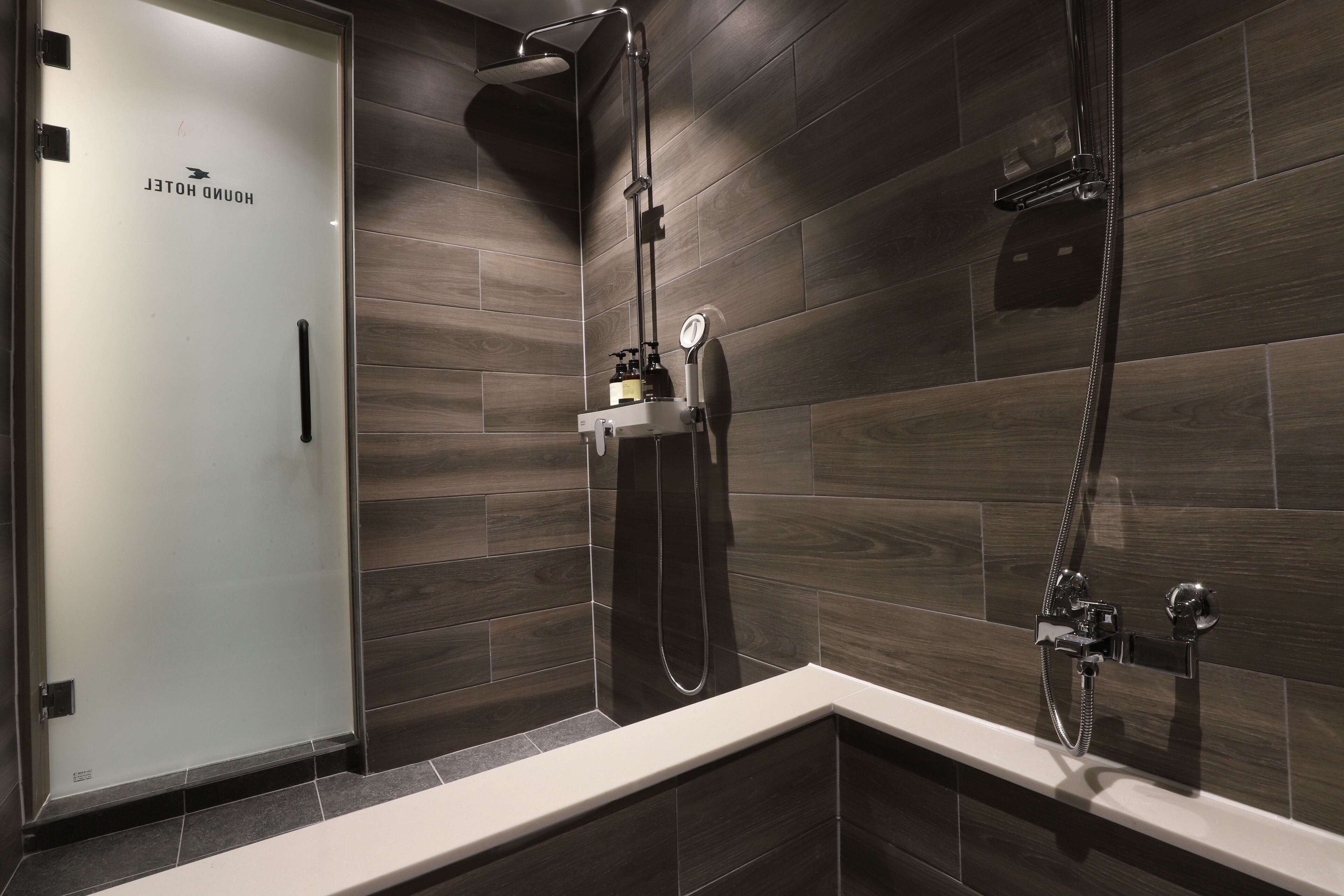 A modern bathroom with a shower, a toilet, and a sink.