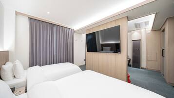 A hotel room with two beds, a large mirror, and a wardrobe.
